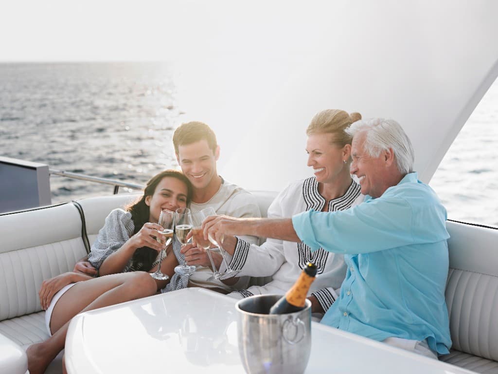 Two generations of a family raising glasses together on a boat