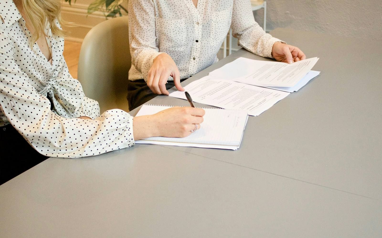 Two people reviewing a set of documents together at a table